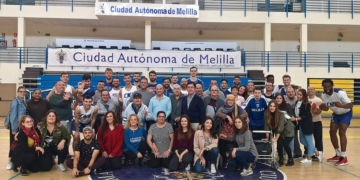 Foto de familia entre los integrantes y usuarios del SPAS y los miembros de la plantilla del Melilla Baloncesto.