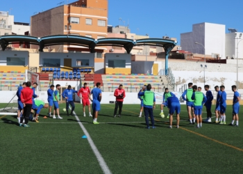 El cuerpo técnico de la entidad melillense dando consignas en el campo federativo de La Espiguera.