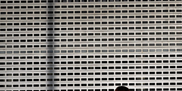 Bucharest (Romania), 29/03/2020.- A Romanian woman wearing a surgical mask passes a big shopping mall locked window in central Bucharest, Romania, 29 March 2020. Romania is in full lockdown across the country. Romanian authorities had confirmed 1815 infected people, 43 deaths and 206 people recovered. (Rumanía, Bucarest) EFE/EPA/ROBERT GHEMENT