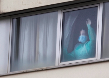 Una sanitaria protegida con mascarilla y un traje es vista en una de las habitaciones de la residencia gestionada por Domus Vi en Barreiro, en Vigo. EFE/Salvador Sas/Archivo