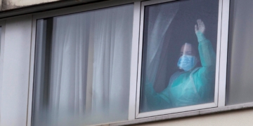 Una sanitaria protegida con mascarilla y un traje es vista en una de las habitaciones de la residencia gestionada por Domus Vi en Barreiro, en Vigo. EFE/Salvador Sas/Archivo
