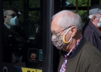 Varios ancianos protegidos con mascarillas se suben y bajan de un autobús en Ourense. EFE/Brais Lorenzo/Archivo