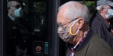 Varios ancianos protegidos con mascarillas se suben y bajan de un autobús en Ourense. EFE/Brais Lorenzo/Archivo