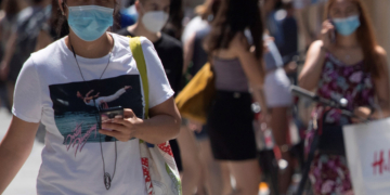 Un policía multa a un ciclista por una infracción cometida y le advierte también de la obligatoriedad de llevar mascarilla cuando se viaja, hoy en el centro de Barcelona. EFE/Marta Pérez
