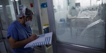 Un sanitario revisa el estado de un paciente afectado por la covid-19 en la Unidad de Cuidados Intensivos (UCI) del Hospital Clínico de la Universidad de Chile en Santiago (Chile). EFE/Alberto Valdés/Archivo