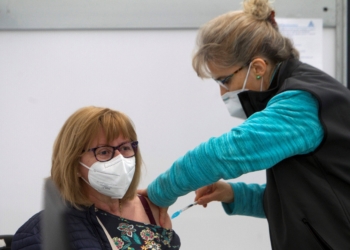 VIGO, 17/04/2021.- Una mujer recibe una dosis de la vacuna de AstraZeneca, este sábado en las instalaciones del Ifevi, donde se está vacunando hoy a 3.500 ciudadanos de entre 60 y 65 años con AstraZeneca y 5.400 mañana, con Pfizer, de 79 a 70 años. EFE/ Salvador Sas