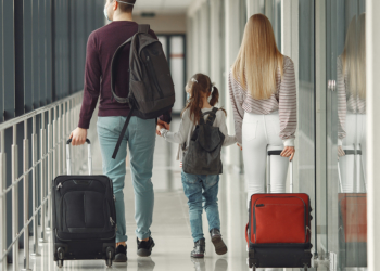 People in airport are wearing masks to protect themselves from virus.
