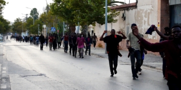 MELILLA, 22/07/2021.- Los inmigrantes subsaharianos recorren una calle de Melilla tras conseguir saltar la valla fronteriza este jueves. Al menos 300 inmigrantes de origen subsahariano consiguieron entrar en España saltando la valla. EFE/Paqui Sánchez