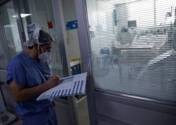 Un sanitario revisa el estado de un paciente afectado por la covid-19 en la Unidad de Cuidados Intensivos (UCI) del Hospital Clínico de la Universidad de Chile en Santiago (Chile). EFE/Alberto Valdés/Archivo