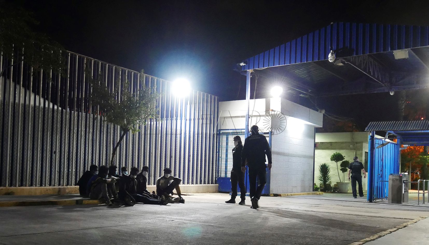 MELILLA, 13/10/2021.- Varios migrantes de origen subsahariano permanecen bajo vigilancia policial tras acceder a Melilla saltando el perímetro fronterizo entre España y Marruecos, en la madrugada de este miércoles. EFE/Paqui Sánchez