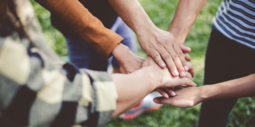 Stacking hands of young teen student, teamwork, togetherness and cooperation concept