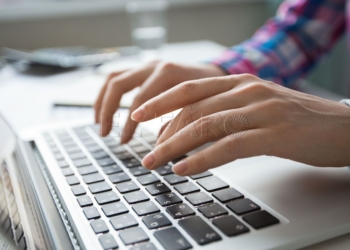 Cropped view of person hands typing on laptop computer