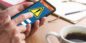 Closeup of male hands touching smartphone screen to read notification.