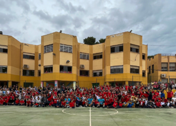 Los componentes del Melilla Sport Capital Baloncesto y su mascota Meli, junto a profesores y alumnos del CEIP León Solá.