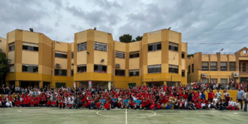 Los componentes del Melilla Sport Capital Baloncesto y su mascota Meli, junto a profesores y alumnos del CEIP León Solá.