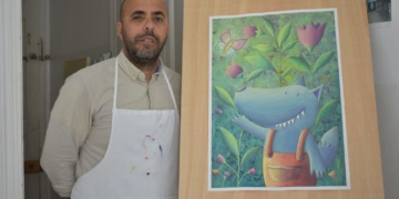 El artista Salah Mezian con una de sus ilustraciones infantiles.