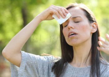 Woman drying sweat using a wipe in a warm summer day