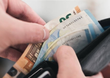 close-up view of hands taking money out of a wallet, spending cash concept