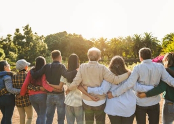 Group of multigenerational people hugging each others - Support, multiracial and diversity concept - Main focus on senior man with white hairs