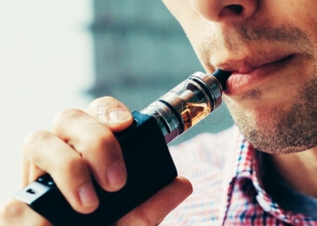 Close up on a man exhaling vapor from an electronic cigarette