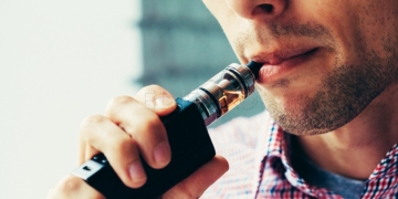 Close up on a man exhaling vapor from an electronic cigarette