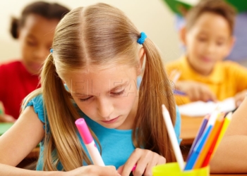 Portrait of lovely girl drawing with colorful pencils at lesson