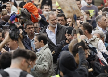 El rey Felipe (c), junto al presidente de la Generalitat de Valencia, Carlos Mazón (c-i), durante su visita a Paiporta este domingo. Gritos de 'fuera', así como lanzamiento de barro, están recibiendo a la comitiva de los reyes de España, el presidente del Gobierno, Pedro Sánchez, y el president de la Generalitat, Carlos Mazón, a su llegada al centro de Paiporta.EFE/ Biel Aliño