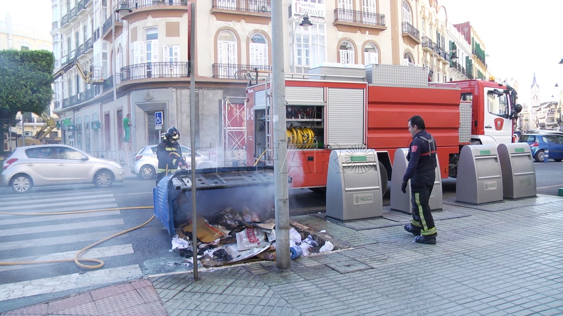 Bomberos apagando el incendio en un contenedor