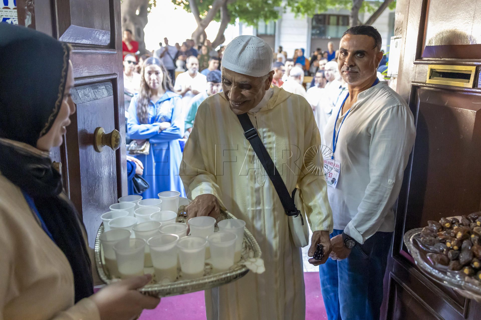 MELILLA, 30/05/2025.- Un hombre toma una bebida de una bandeja este viernes en Melilla en el que cientos de melillenses musulmanes han partido este por la mañana de la ciudad autónoma para realizar el Hajj, la tradicional peregrinación hacia La Meca, uno de los cinco pilares sagrados del islam. EFE/ Jose Manuel Giner Gutiérrez