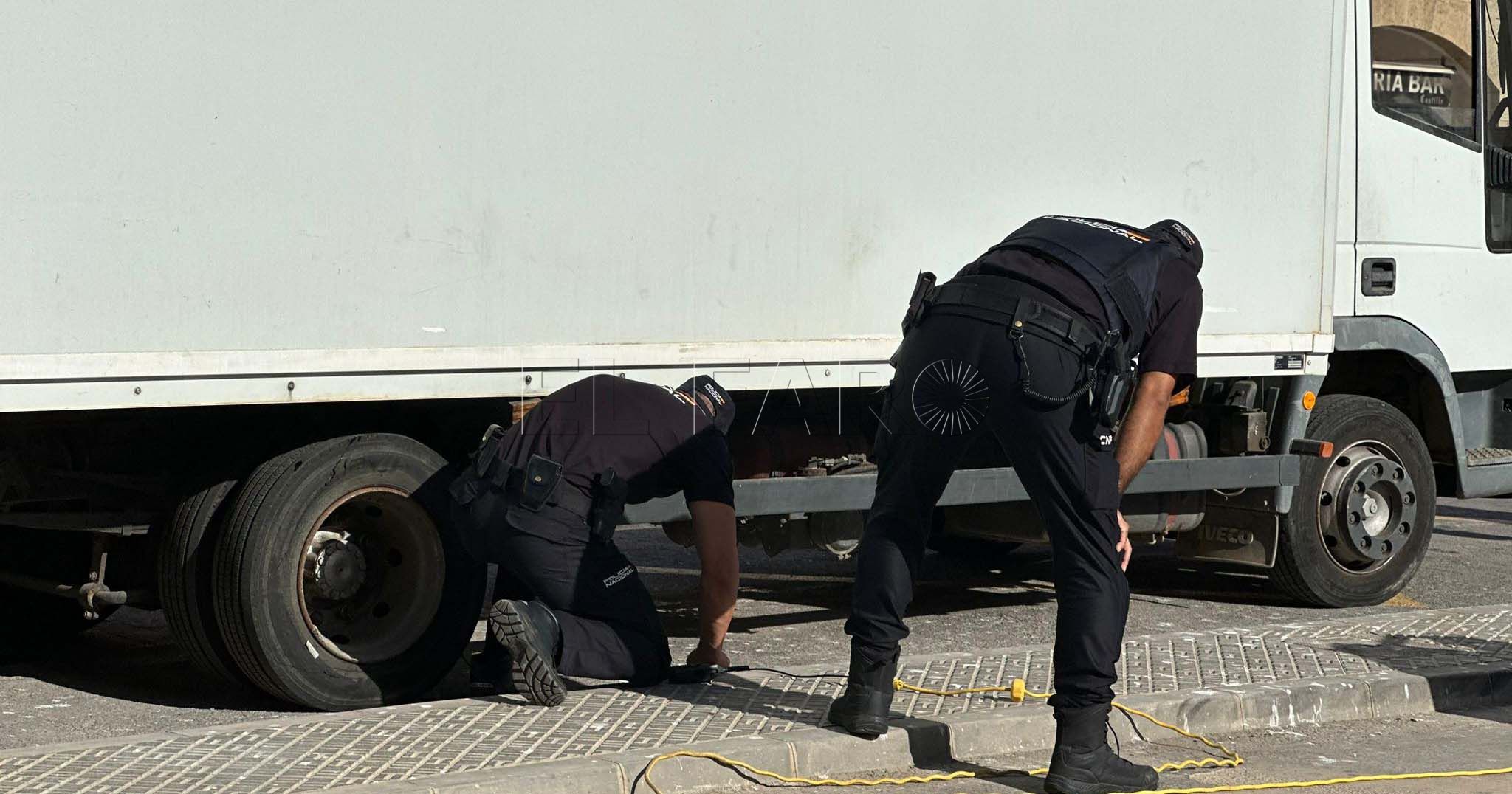 Policías nacionales buscan bajo los camiones