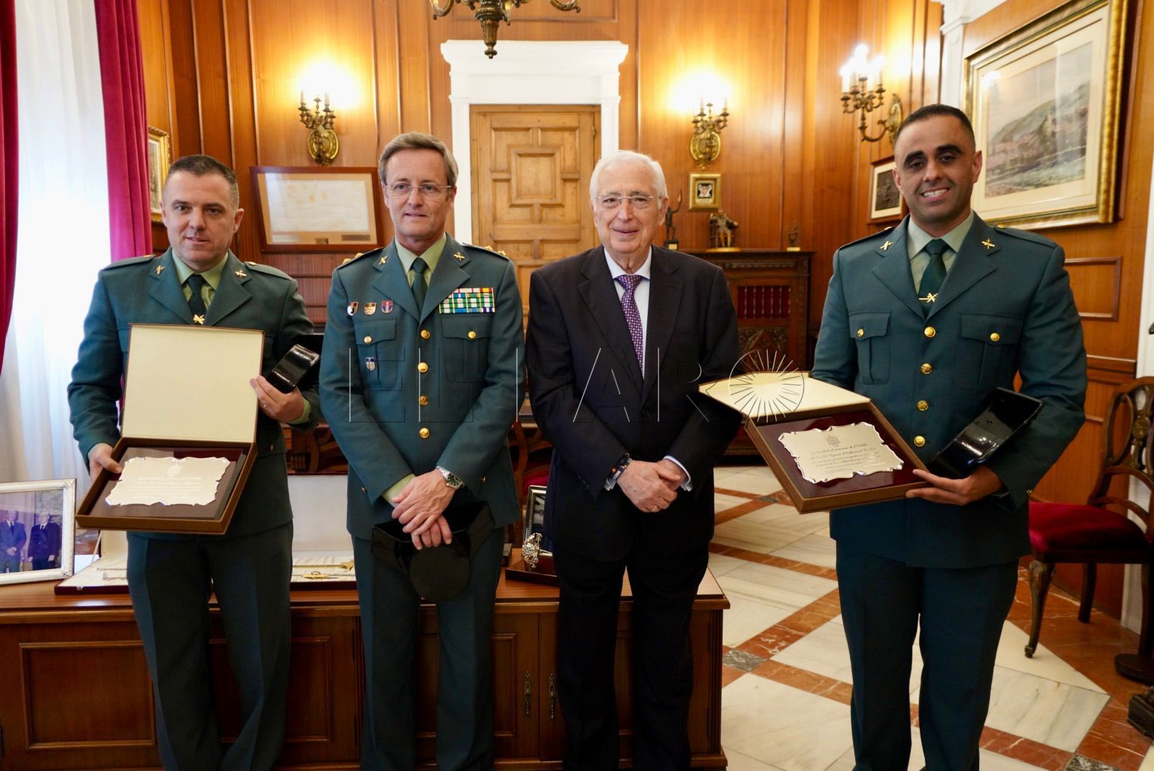 Ramsis Mohamed y Juan Troyano recibiendo la placa de agradecimiento a su actuación, junto al presidente local. -Cedida por la CAM-