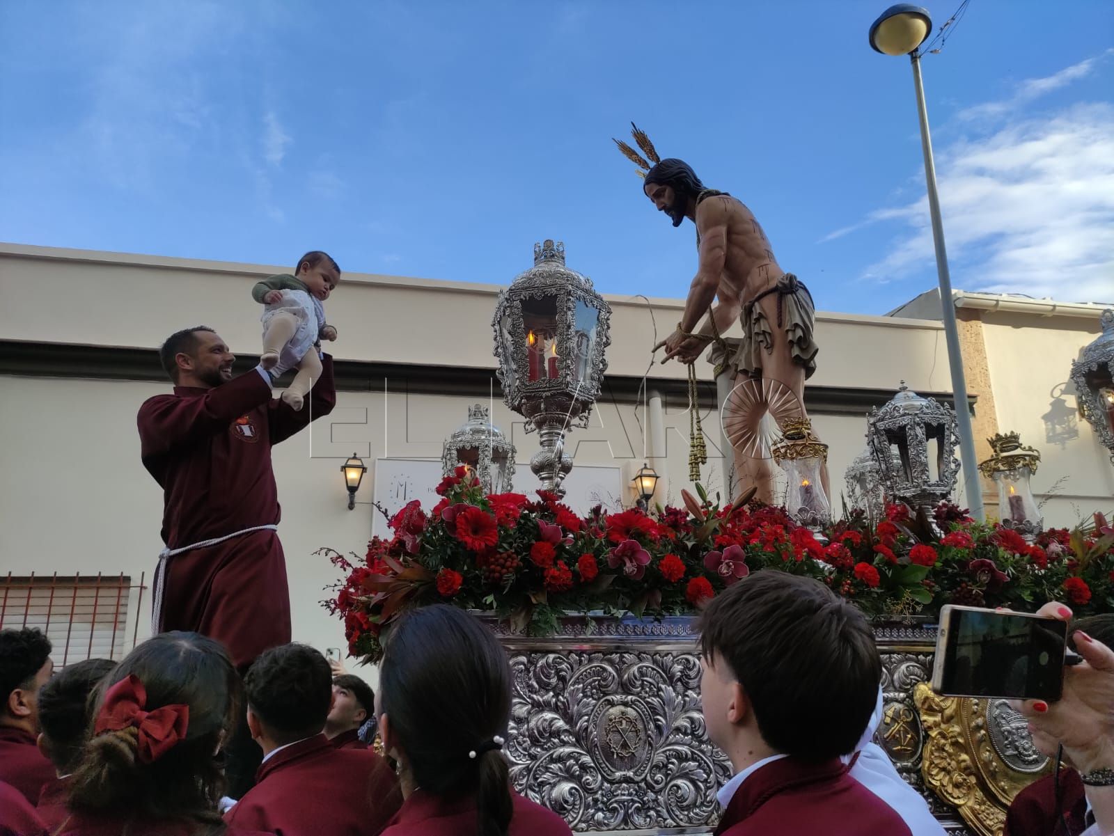 Acto de presentación de bebés a Jesús de la Fragelación y la virgen Mayor de los Dolores frente a la Casa Hermandad. -AGC-