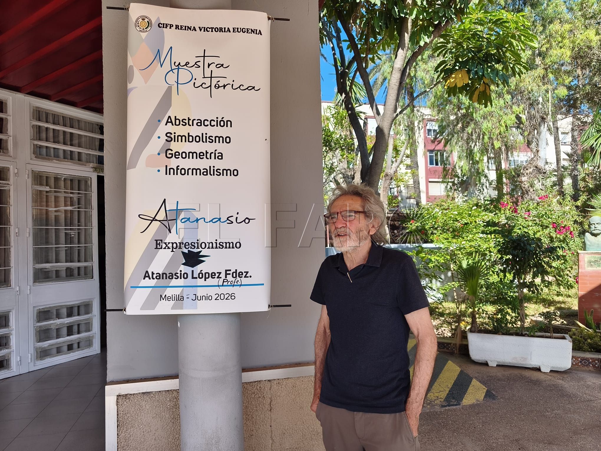 Tana junto al cartel de su exposición en el interior del salón de actos de CIFP Reina Victoria Eugenia. -AGC-