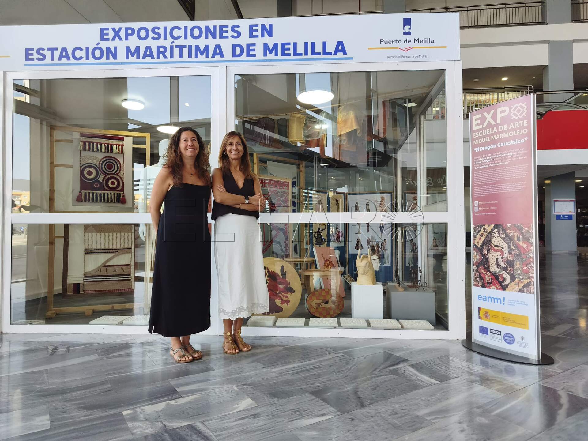 Laura Canto, jefa de estudios adjunta de la EAMM, y Bárbara Judel, directora de la EAMM junto a la exposición.  -AGC-