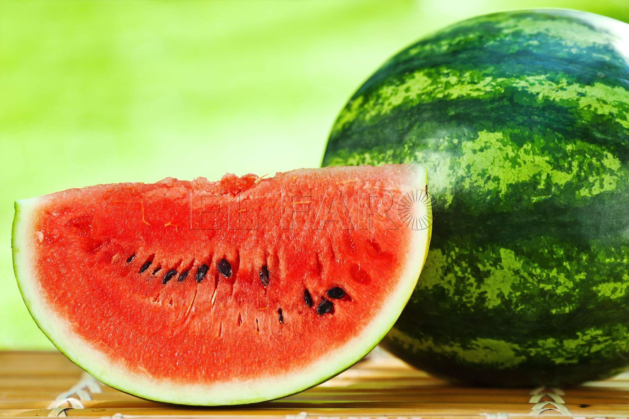 11870356 - juicy slice of big watermelon against natural green background in spring