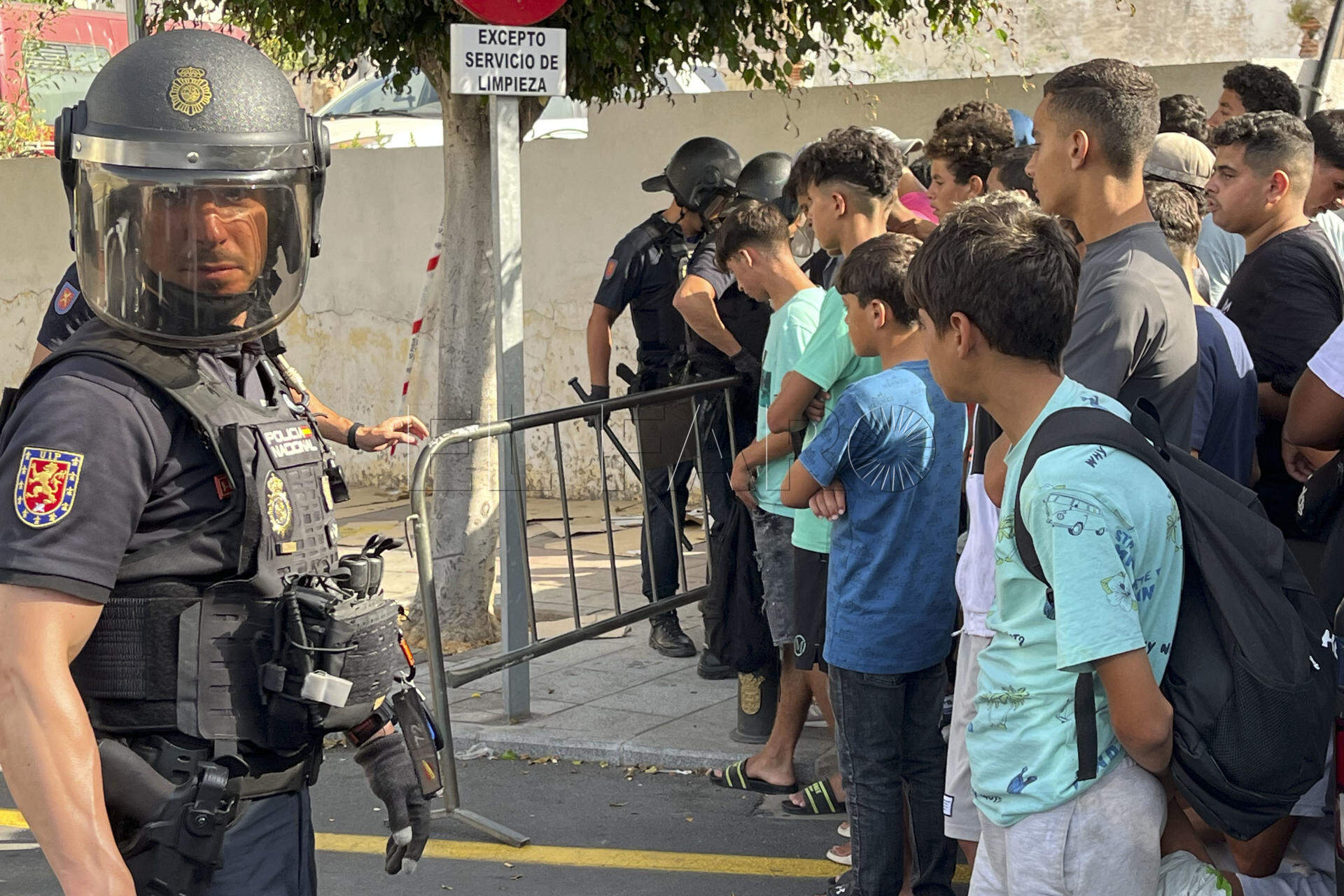 FOTODELDÍA CEUTA, 10/08/2026.-Multitud de menores migrantes esperan para su filiación frente a la Jefatura Superior de la Policía Nacional en Ceuta este lunes. La situación en Ceuta sigue lejos de normalizarse, con campamentos provisionales para muchos migrantes y miles de menores a la espera de una solución, y continúa marcando la disputa entre el Gobierno y el PP, que mantiene el pulso para que tres ministros comparezcan en el Senado aunque desde el Ejecutivo solo piensen hacerlo en el Congreso. -EFE/ Reduan