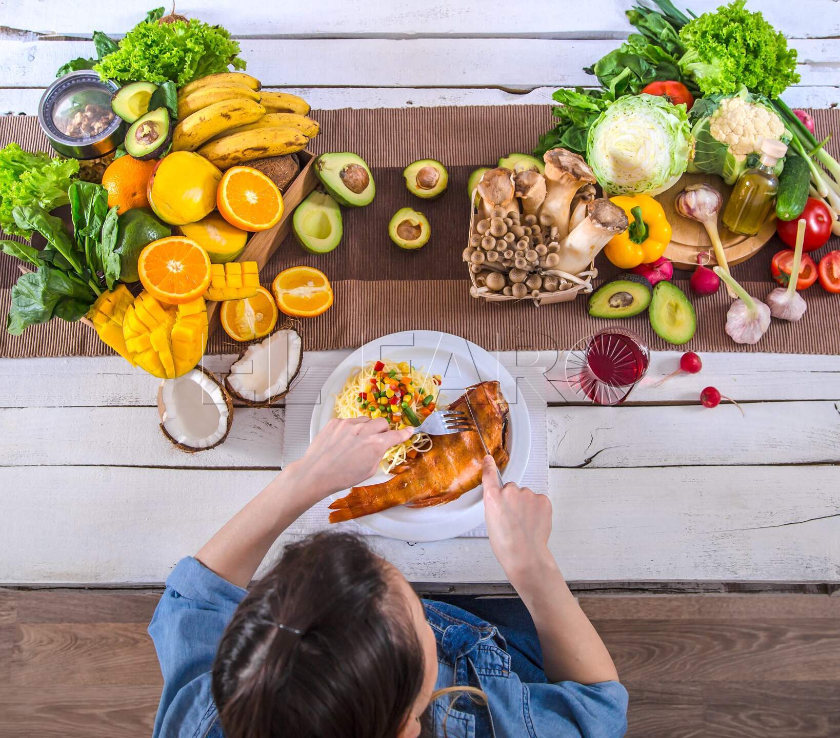 Woman at the dining table with a variety of organic healthy food , top view. The concept of healthy eating and celebration